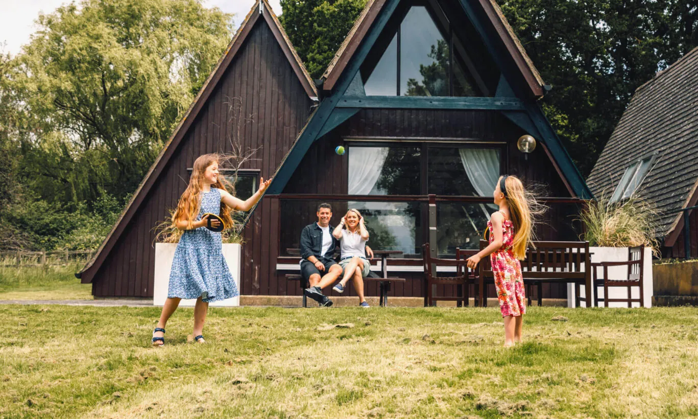 Family playing catch outside lodge accommodation