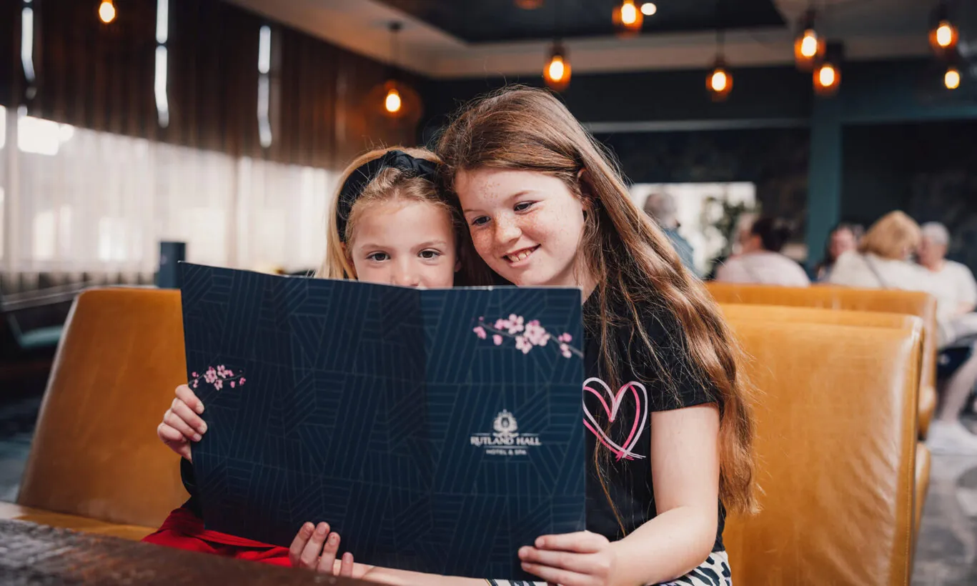 Two girls looking at the food menu at Blossoms Restaurant & Bar