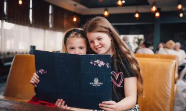 Two girls looking at the food menu at Blossoms Restaurant & Bar